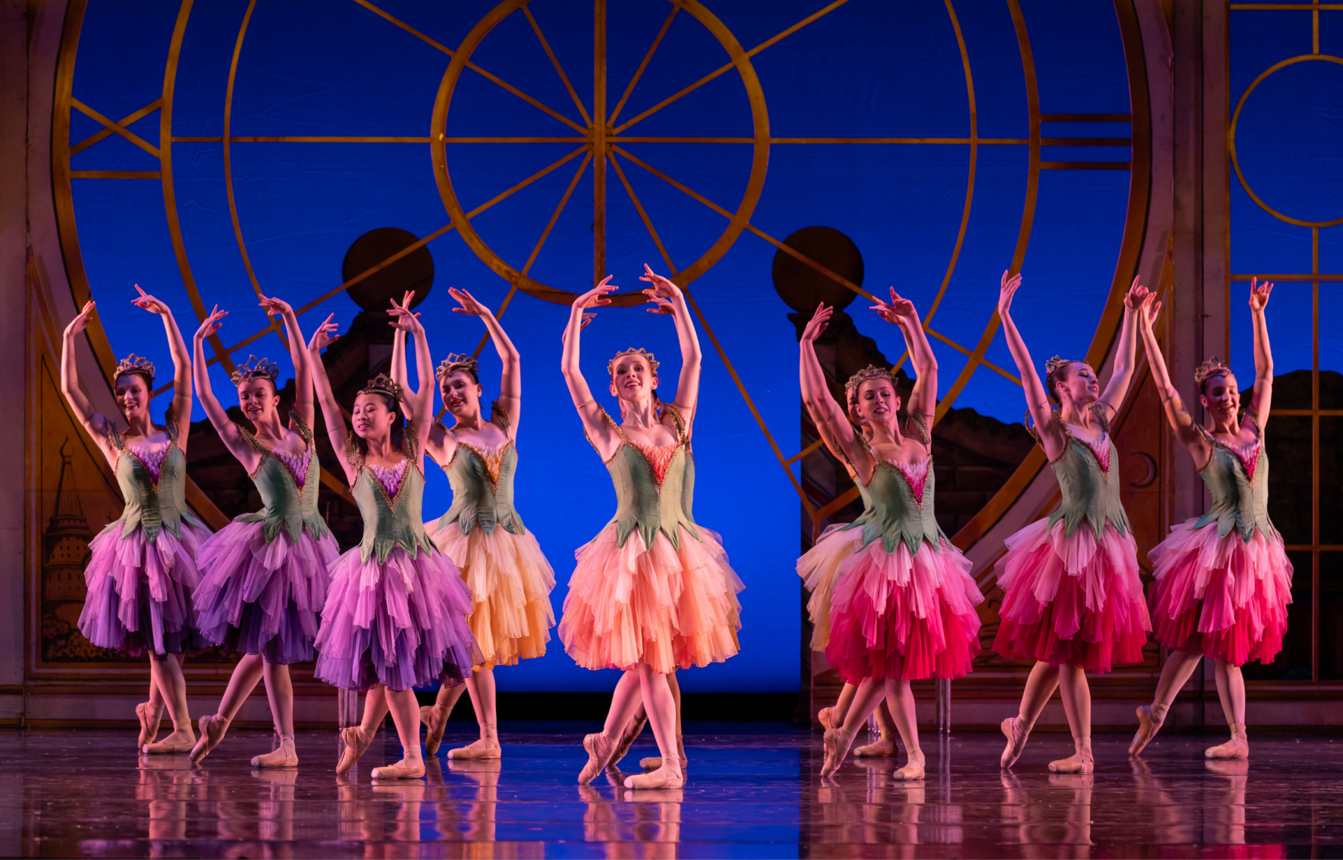 Ballet dancers in flower costumes of pink, purple, peach, and yellow in The Nutcracker.