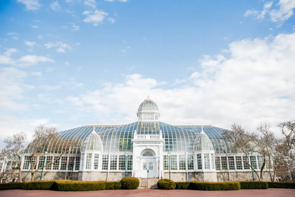 Image of the Franklin Park Conservatory and Botanical Gardens located just north of Downtown Columbus with rolling white clouds in the sky.